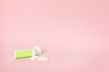 container with blank label and some effervescent pills (antiacids or supplements) on a blue background with pink space for text