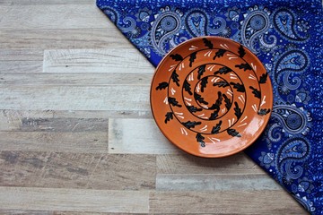 clay plate and blue scarf on wooden table