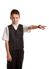 Young confident boy in school uniform pointing away on white background