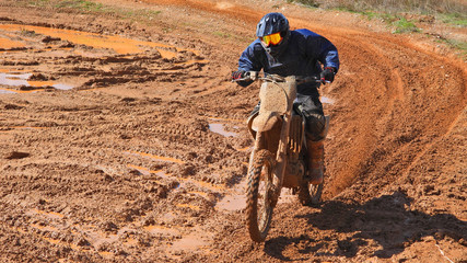 Zoom photo of unidentified motocross rider performing extreme stunts in off road dirt track