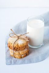 Stacked cookies on a linen napkin and a glass of milk. Close up.