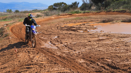 Zoom photo of unidentified motocross rider performing extreme stunts in off road dirt track