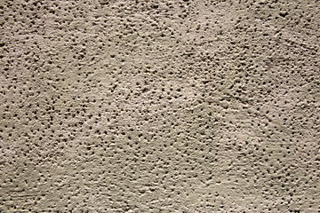 concrete wall full of small holes