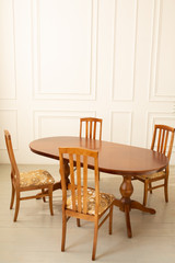 Fototapeta na wymiar A classic set of wooden furniture for the kitchen. A set of chairs to the table in a classic interior