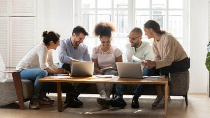 Diverse students studying together working on common research project