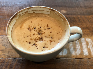 Hot cappuccino cup on wooden table