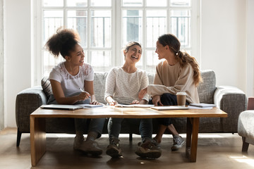 Diverse girls friends laughing chatting take break during study process