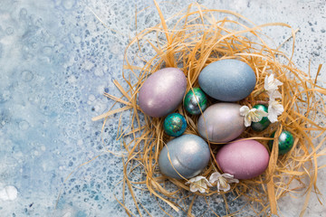 Fototapeta na wymiar Colorful pastel easter eggs on stone background with space for text, top view.