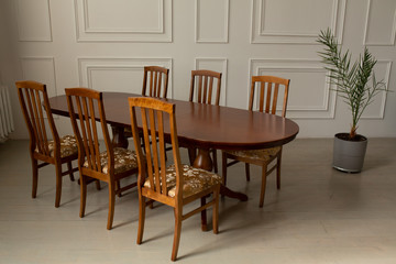 Fototapeta na wymiar A classic set of wooden furniture for the kitchen. A set of chairs to the table in a classic interior