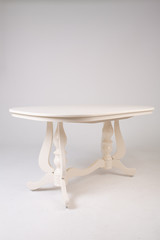 Single white round table with empty surface and carved legs on an isolated white background