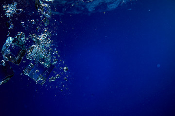 Ice cubes falling into the water