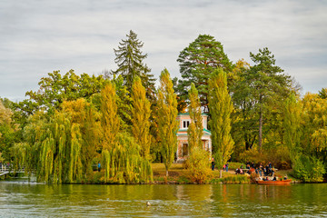 Uman, Ukraine - Sep 30, 2019: Autumn garden lake landscape with tourists and yellow trees, Sofievka park.