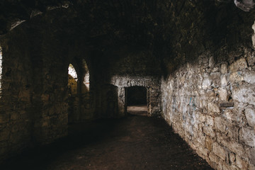 Inside of ruins of Chortkiv castle, Ukraine. Destroyed ruined brick walls and window light in dark indoors of medieval castle, historical defence fortress in Europe