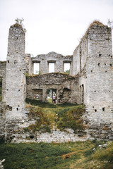 Fototapeta na wymiar Old ruins of Skala Podilskyi castle, Ukraine. Destroyed ruined stone walls of medieval castle and green grass, historical defence fortress in Europe