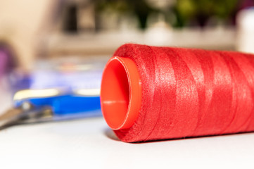 spool of red thread on the table at the tailor