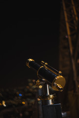 Telescopio en la Torre Eiffel de noche con bokeh de fondo