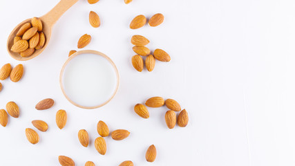 Almond milk with almond on white background. Homemade organic almond milk in a paper cup for healthy breakfast. Vegan milk from almonds nuts in kraft paper cup. Alternative milk. Zero waste