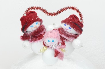 snowman family parents with children during snowfall