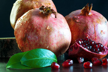Sliced ​​red pomegranate on a wooden stand. Juicy pomegranate berries.
