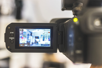 Professional film production: Male filmmaker is recording with a professional movie camera. Close up of camera lcd screen