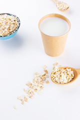 Oat milk. Organic oat milk in a paper cup. Healthy vegan non-dairy organic drink with oat flakes. Healthy alternative milk. Zero waste