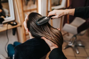 Gordijnen Beautiful young woman preparing for haircut at a beauty salon. © hedgehog94