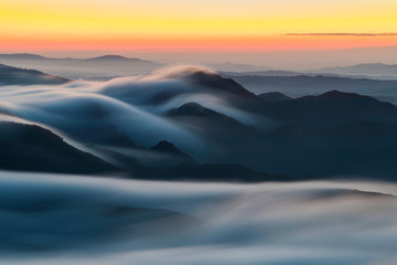 Landscape at sunrise in the cloudy mountains with blue colors and orange horionte, Montserrat, Spain