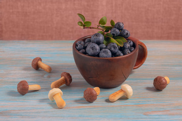 there are blueberries with leaves and shortbread cookies in the form of mushrooms. A brown Cup...