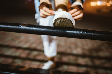 Close-up young woman tying her shoelaces