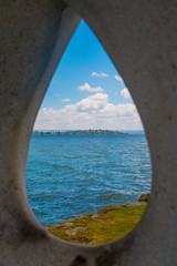View at Lake Rotorua through tear-shaped hole in statue from Hatupatu Scenic Point, Rotorua, New Zealand