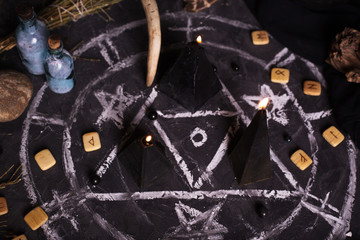 Black magic ritual with candles and runes
