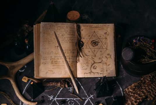 Open Old Book With Magic Spells, Runes, Black Candles On Witch Table. Occult, Esoteric, Divination And Wicca Concept.