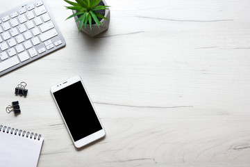 White desk office with laptop, smartphone and other work supplies with cup of coffee. Top view with copy space for input the text. Designer workspace on desk table essential elements on flat lay