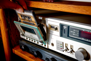 Cassette tape is dropped into a player to listen to music