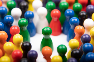 wooden green figurine surrounded by a large group, standing for speaker or critical situation