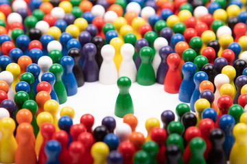 wooden green figurine surrounded by a large group, standing for speaker or critical situation