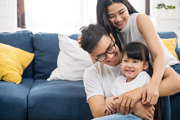 Fototapeta premium Portrait of happy Asian family spending time together on sofa in living room. family and home concept.