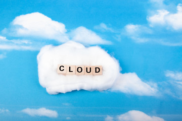 word cloud made of wooden blocks, sky with clouds as background