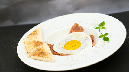 fried egg on the bacon and toast bread 
