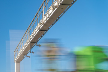 Obraz premium truck drive through the highway through the toll gate, toll charges, blurred motion in the image