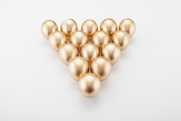 Golden balls are folded in a triangle, as in billiards, on a white background. Concept photo for a game of billiards.