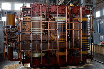High-voltage three-phase transformer during overhaul at the factory. Winding transformer