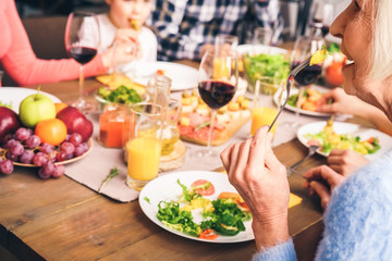 Grandma eats at the table and talks to her family