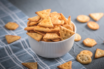 Fototapeta na wymiar Fresh cheese cracker biscuits with herbs on dark background