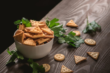 Fototapeta na wymiar Fresh cheese cracker biscuits with herbs on dark background