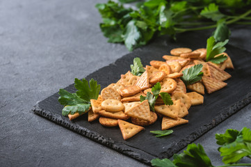 Fresh cheese cracker biscuits with herbs on dark background
