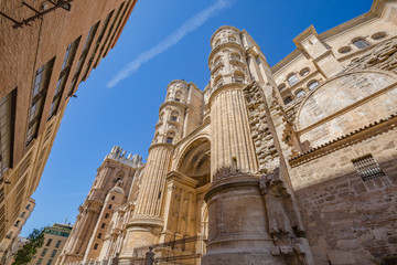 Fototapeta na wymiar Walking Malaga old town streets. View of Cathedral of Incarnation exterior walls