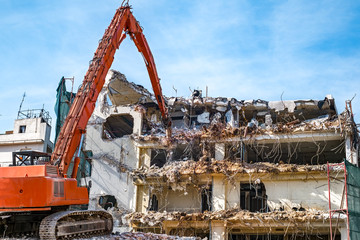 Fototapeta na wymiar Building demolition with hydraulic excavator