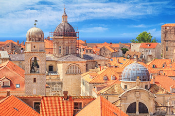 Fototapeta na wymiar Summer mediterranean cityscape - view of the roofs of the Old Town of Dubrovnik with the Church of St. Blaise and the Assumption Cathedral, on the Adriatic coast of Croatia