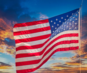 An American flag waving in the wind against a blue sky